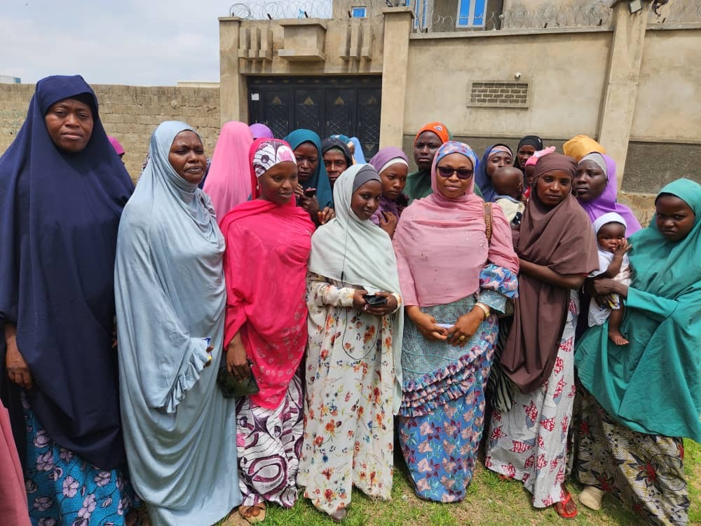 VOICEHER Community - Women and children gathered with VOICEHER banner